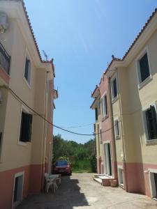 an alley between two buildings with a car parked at Irini Apartments Anaxos in Anaxos