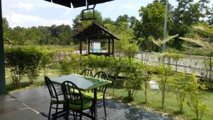 een tafel en stoelen op een patio met een prieel bij Selesa View Gambang in Simpang Pulau Manis