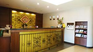 a bar in a restaurant with a yellow wall at Metropolis Hotel in Taoyuan