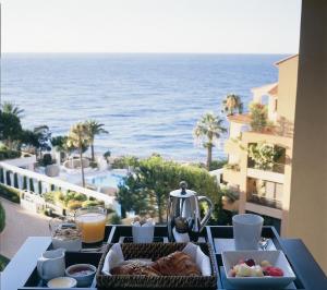 a tray of food on a table with a view of the ocean at Hôtel Columbus Monte Carlo in Monte Carlo