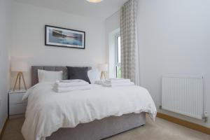 ケンブリッジにあるTailored Stays - Executive Town Houseの白いベッドルーム(白いシーツを使用した大型ベッド1台付)