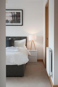 - une chambre avec un lit et une lampe sur une table de chevet dans l'établissement Tailored Stays - Executive Town House, à Cambridge