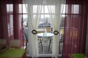 una finestra con tende bianche e un tavolo sul balcone di Villa Ilona a Ahlbeck