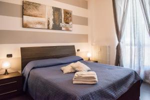 Un dormitorio con una cama azul con toallas. en Casa Borgone, en Turín
