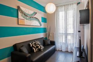 sala de estar con sofá negro y rayas azules y blancas en Casa Borgone, en Turín