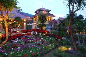 a garden in front of a house with flowers at Phurua Resort in Phu Rua