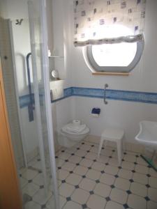 ein Bad mit einem WC, einem Fenster und einem Waschbecken in der Unterkunft villa Bella behindertenfreundliche in Ahlbeck