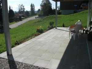 a patio with a bench and a view of a road at Haus Lenzhalde in Oberreute