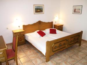 a bedroom with a wooden bed with two night stands and two tables at Hotel Kralj Tomislav in Nova Gradiška +45 photos