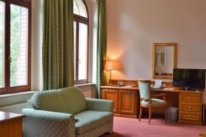- un salon avec une chaise et un bureau dans l'établissement Hotel Artushof, à Dresde
