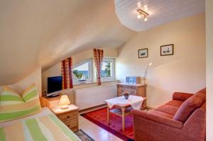 a bedroom with a bed and a couch and a tv at Panoramablick _ Heringsdorf in Heringsdorf