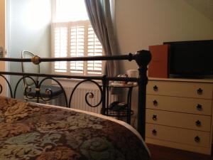 a bedroom with a bed and a dresser with a television at Balham Lodge in London