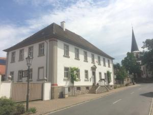 un gran edificio blanco con un campanario en una calle en Ferienwohnungen im SCHUL & RATHHAUS Obervolkach, en Volkach