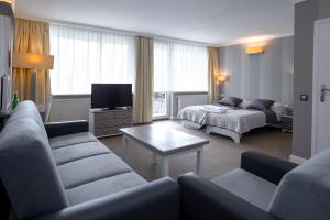 ein Wohnzimmer mit einem Sofa und einem Bett in der Unterkunft Hotel Niedźwiadek in Wdzydze Kiszewskie