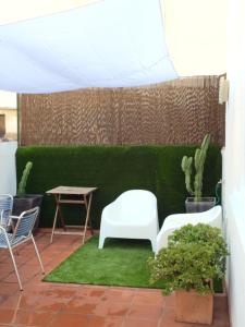 a patio with two chairs and a table and a green wall at Clemens in Málaga