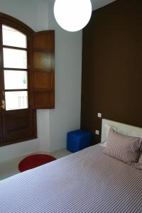 a bedroom with a white bed and a blue stool at Clemens in Málaga