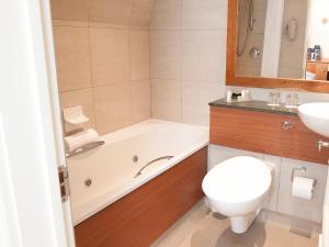 a bathroom with a tub and a toilet and a sink at Harbour Heights Hotel in Poole +35 photos