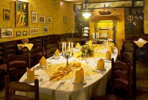 uma sala de jantar com uma mesa com guardanapos amarelos e velas em Hotel Victoria em Szczecin