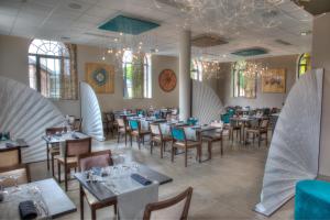 une salle à manger avec des tables, des chaises et des planches de surf dans l'établissement Hôtel de la Tabletterie, à Méru