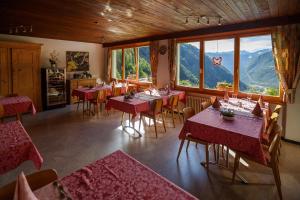 un restaurante con mesas y sillas con montañas al fondo en Agriturismo Miravalle, en Brusio