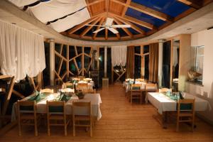 uma sala de jantar com mesas e cadeiras e um tecto em Agriturismo Miravalle em Brusio