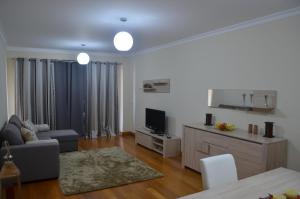 een woonkamer met een bank en een tv bij Enzo Apartament in Funchal