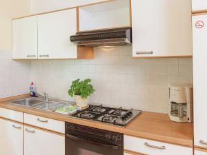 uma cozinha com armários brancos e um forno com placa de fogão em Holiday home in the Gro breitenbach em Altenfeld