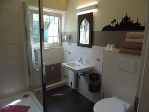 a bathroom with a shower and a sink and a toilet at Hotel Sandmanns am Dom in Cologne +28 photos