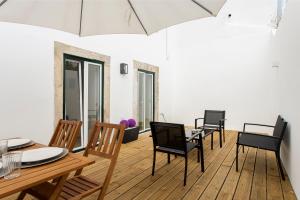uma sala de jantar com uma mesa e cadeiras e um guarda-sol em Castelo Picão Apartments em Lisboa