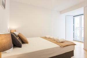 リスボンにあるカステロ ピカオ アパートメンツの白いベッドルーム(大型ベッド1台、窓付)