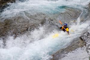 un hombre en un kayak en una cascada en un río en Hotel La Posada, en Broto