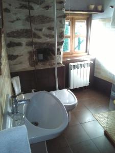 a bathroom with a sink and a toilet at Casa do Solpor in La Teijeira