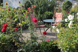 two chairs and a table in a garden with flowers at No. 73 - Idylle im Rebenmeer in Pleisweiler-Oberhofen