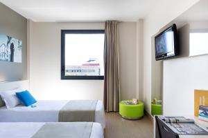 a hotel room with a bed and a flat screen tv at B&B Hotel Ferrara in Ferrara