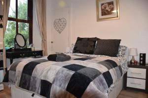 a bedroom with a bed with a black and white blanket at Flat G/R 59 Erskine Street Aberdeen in Aberdeen