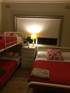 a bedroom with two bunk beds and a lamp on a table at Guesthouse 83 in Cronulla