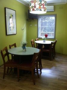 a dining room with two tables and chairs and a window at Guesthouse 83 in Cronulla