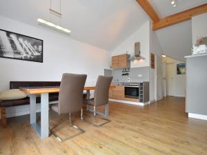cocina y comedor con mesa de madera y sillas en Modern Apartment in Willingen near Ski Lift, en Willingen