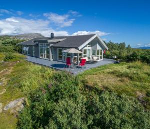 a house on top of a hill with a yard at Vestfjord Panorama Villa in Nes