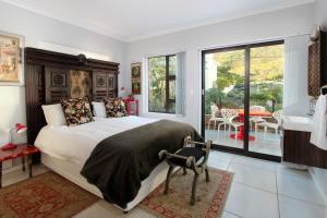 a bedroom with a large bed and a balcony at The Nantucket in Hermanus