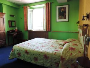 Schlafzimmer mit einem Bett mit grünen Wänden und einem Fenster in der Unterkunft Hotel De Provence in Digne-les-Bains