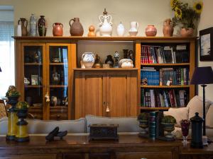 a living room with a couch and shelves of vases at Casa Maravilla in Faro de Peñas