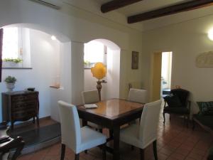 薩雷諾的住宿－Salerno Domus Claudia，一间带木桌和白色椅子的用餐室