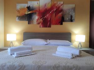 1 dormitorio con 1 cama con 2 almohadas y 2 lámparas en Maison Margherita, en Santa Teresa Gallura