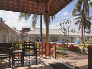 a patio with two benches and a pool at Lombok Holiday Hotel in Kuta Lombok