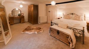 a bedroom with a large bed and a mirror at Blue Bell Cottage in Ollerton