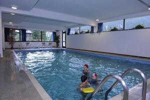 un groupe de personnes dans une piscine dans l'établissement Residence Edelweiss, à San Martino di Castrozza