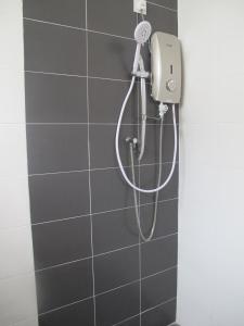 a shower with a shower head in a bathroom at Properties Homestay, Balik Pulau in Balik Pulau