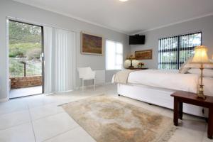 a bedroom with a large bed and a large window at The Nantucket in Hermanus