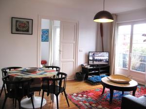 a living room with a table and chairs and a television at IBERIA 1 appartement T3 à 200 m de la plage avec parking privé in Hendaye